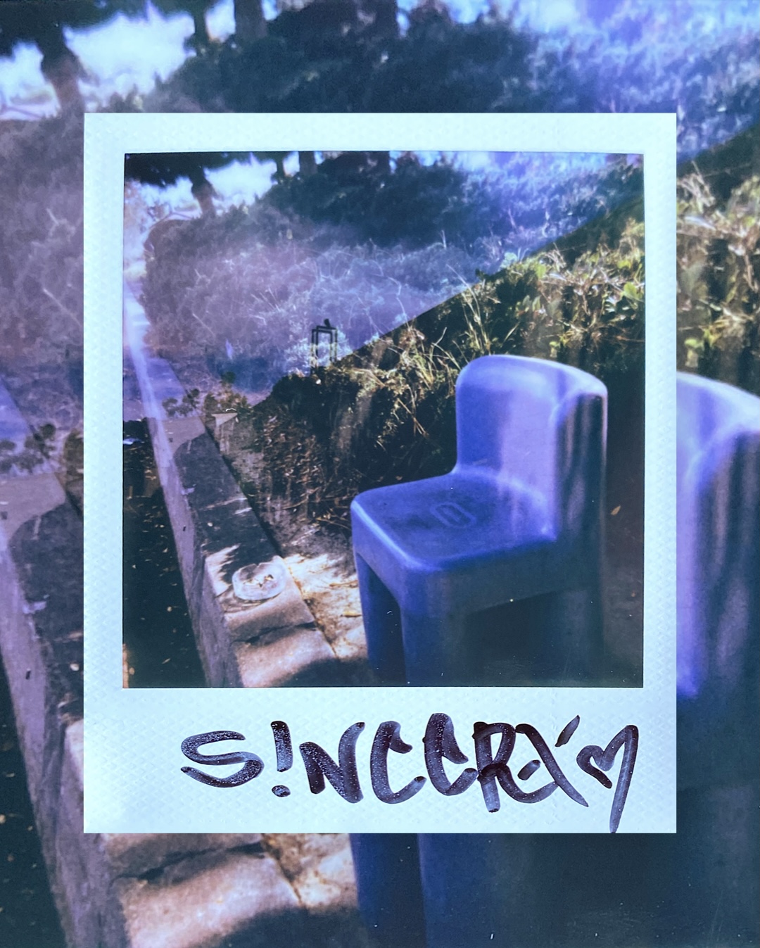 a double-exposed Polaroid layering a small blue chair over a sunlit garden path, signed sincerx